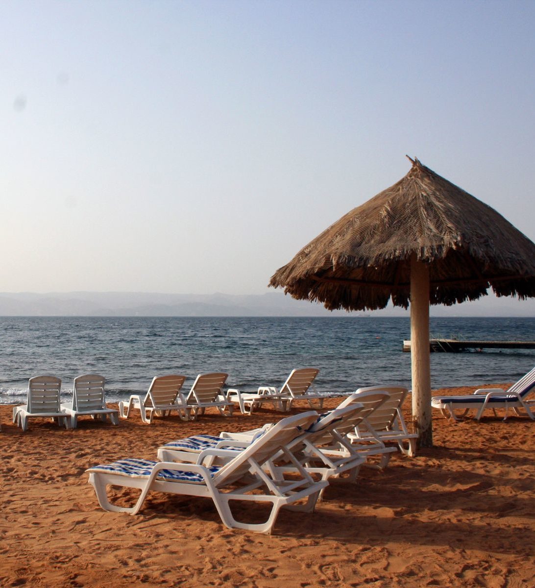Rondreis Jordanië, Aqaba, strand met bedden en parasol