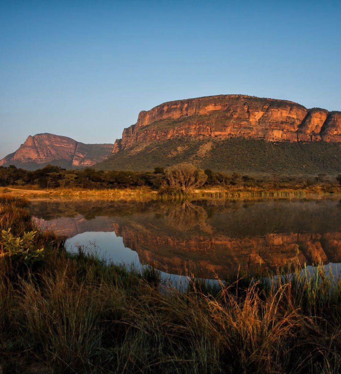 Rondreis Zuid-Afrika, Entabeni Game Reserve, zonsopkomst in een landschap met bergen en een meer Rondreis Zuid-Afrika, Entabeni Game Reserve, zonsopkomst in een landschap met bergen en een meer