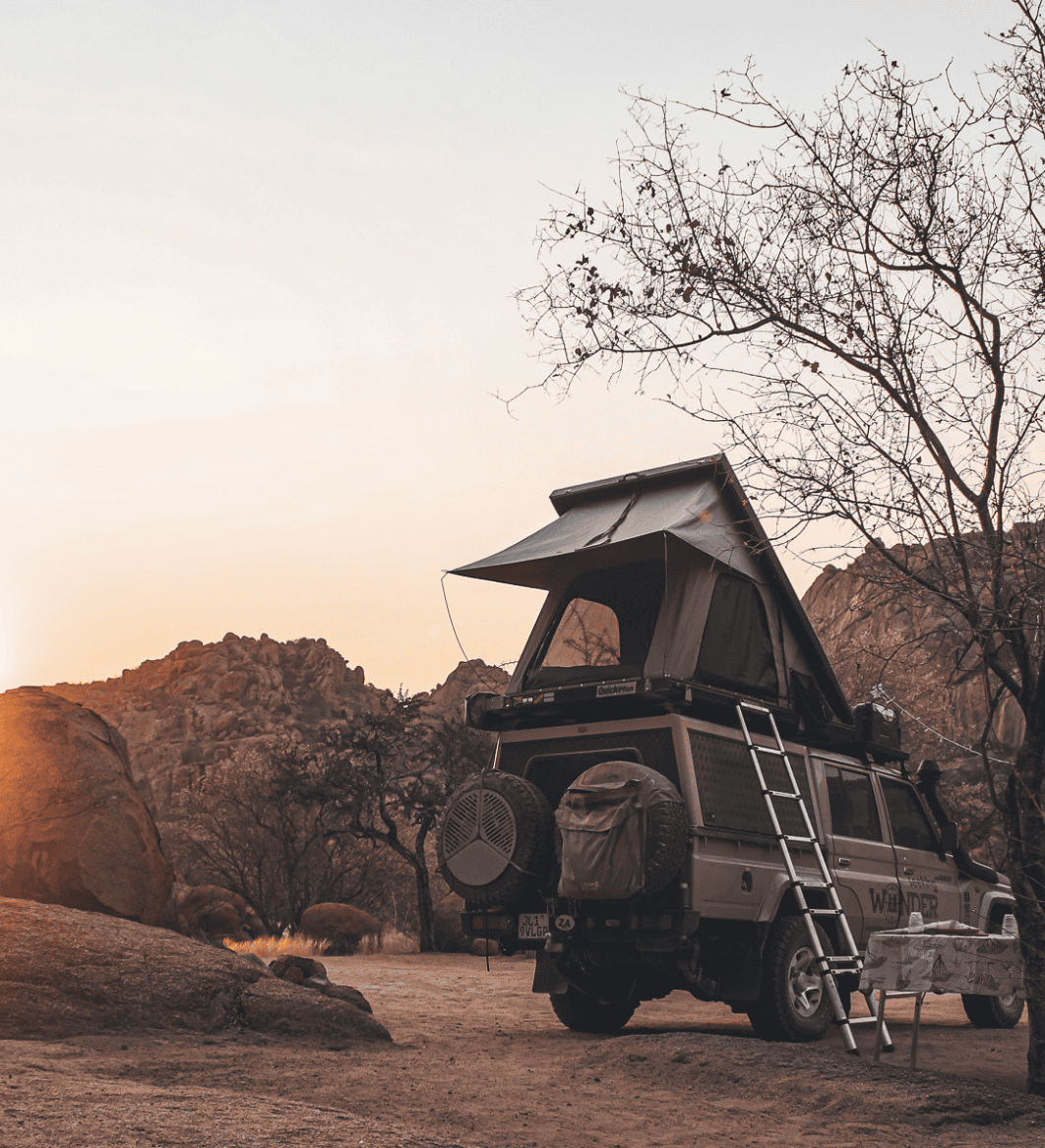 rondreis camping expeditie door namibie en zuid afrika range rover met daktent bij zonsondergang